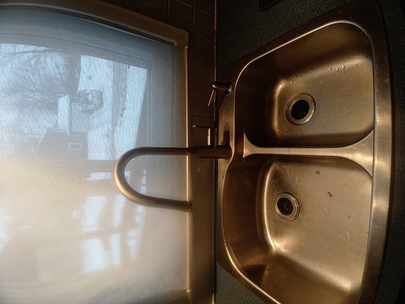 Replaced kitchen sink faucet that was not delivering hot water. Installation of new pull-down faucet with brushed nickel/bronze finish was completed successfully, resolving the hot water issue in the kitchen while maintaining functionality of the secondary fixture.
