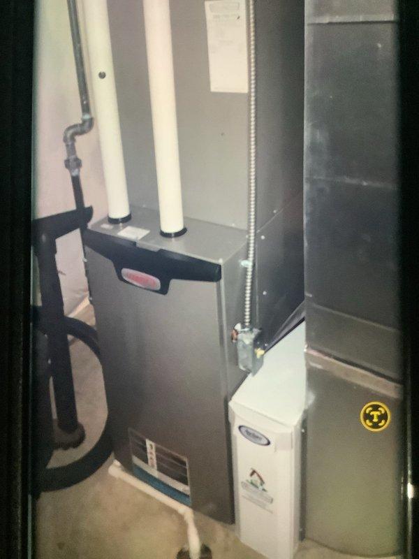 Performed scheduled heating system tune-up service (rolled from 1/13). Inspected residential furnace unit with PVC exhaust venting and drainage system. Conducted operational check using hex key tool for access to internal components. System functioning properly with no issues found.