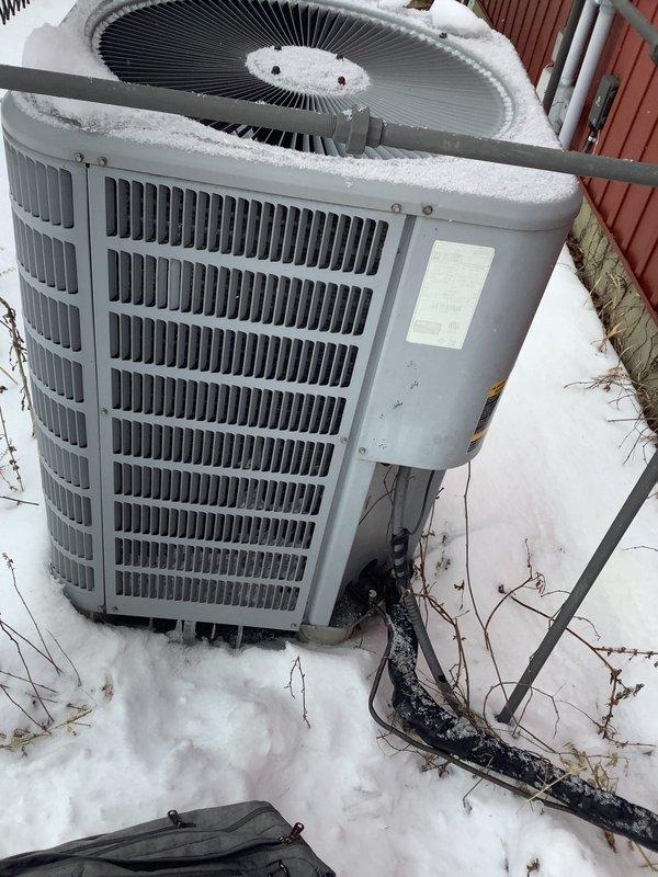 Diagnosed heat pump exhibiting poor heating performance and unusual operational noise. Recommended installation of outdoor temperature sensor to optimize system integration with customer's existing wood burner that shares ductwork. Documented current system condition with exterior unit photos showing snow accumulation and mounting location.