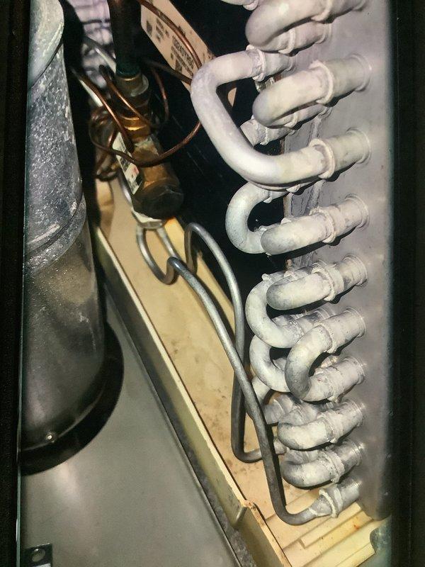 Performed annual heating maintenance on 12-year-old system. Inspected motor assembly and electrical connections, noting normal wear on brass fittings. Examined evaporator coil assembly and refrigerant lines, observing some frost/dust accumulation on the coil surfaces. System operational and functioning within normal parameters.