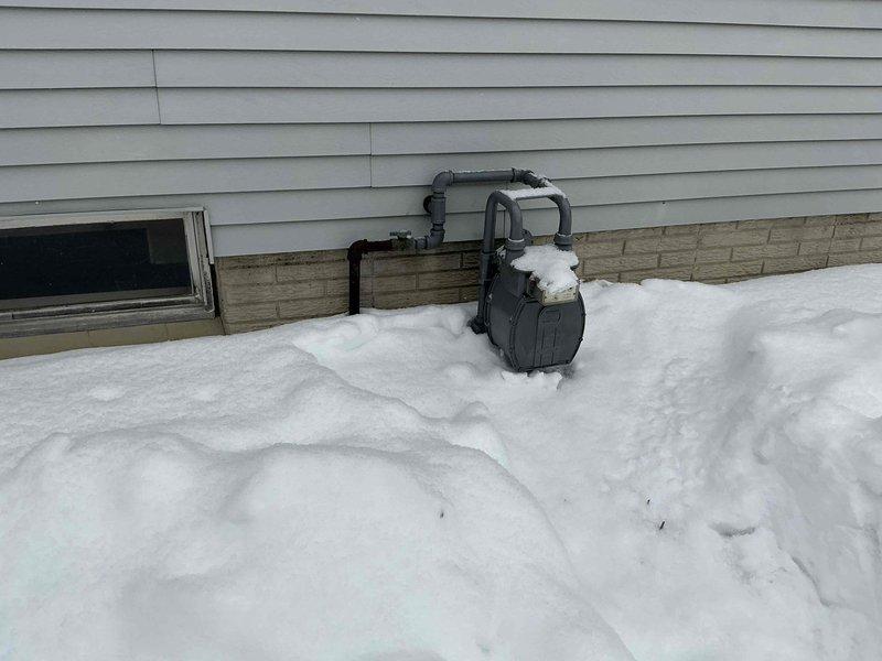 Conducted generator installation estimate at residential property with existing gas service. Inspected main electrical panel to assess available space for generator transfer switch integration. Evaluated exterior wall location with gas meter for potential generator placement, noting significant snow accumulation that will need to be addressed before installation.