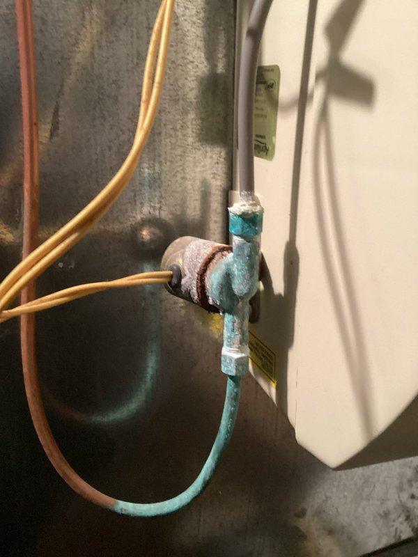 Performed scheduled heating maintenance visit that was previously owed to customer. Inspected furnace system with attached Aprilaire humidifier and noted significant corrosion on copper elbow joint connecting to PVC pipe, showing signs of leakage and mineral buildup. Recommended repair of deteriorated connection to prevent future water damage and ensure proper system operation.
