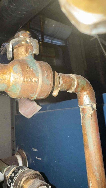 Responded to customer complaint of gas odor. Inspection revealed severely corroded copper water valve with significant oxidation and verdigris formation. Examined furnace interior, noting heat-damaged metal components, discolored ductwork, and accumulated debris around blower wheels with possible electrical connection issues.