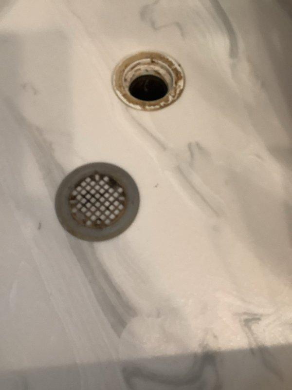 Responded to a water leak service request for a 25-year-old home. Investigated water intrusion between floors, focusing on bathroom plumbing fixtures. Identified mineral buildup around sink drain as potential contributing factor. Performed necessary repairs to stop leak transmission from upper to lower level, preventing further damage to ceiling-mounted light fixture in the kitchen area below.