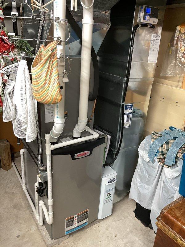 Performed standard furnace maintenance service, including visual inspection of the basement-installed HVAC system. Checked furnace with visible "DANGER" label, examined PVC exhaust/intake piping, and inspected connected air handler/heat pump unit with digital control panel. Completed system evaluation with appropriate service tools.