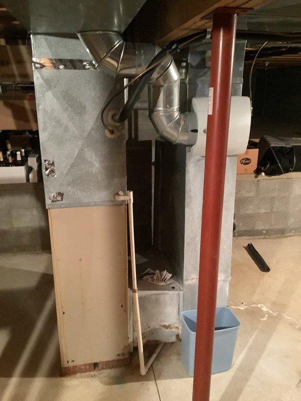 Completed installation of a new 80% efficient furnace and air conditioning system in customer's basement. Installed new galvanized ductwork with proper connections and seams, including insulated black return duct with 90-degree bend. System includes copper refrigerant lines connecting to the outdoor AC unit, with all necessary electrical connections properly secured.