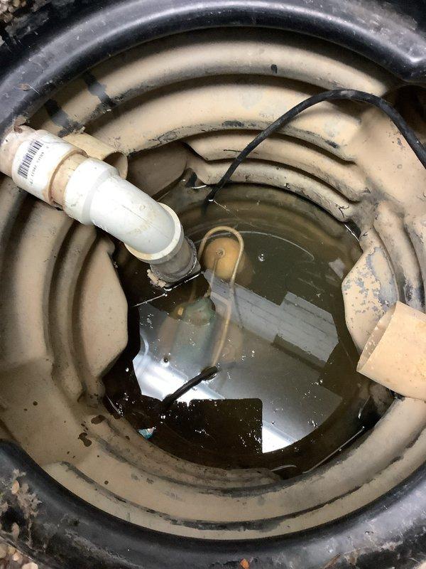Responded to service call for non-functioning sump pump that had been spraying water, which caused electrical failure affecting both the pump and nearby dryer. Inspected sump pit, found pump submerged in murky water with visible float switch malfunction. Replaced damaged sump pump system, ensuring proper installation of discharge pipe and electrical connections. Verified system operation before completion. Customer advised that electrician was scheduled to address related electrical issues.