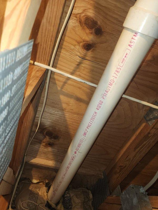 Replaced non-compliant PVC vent piping on water heater installation to meet inspector requirements. Installed proper ASTM-rated solid core PVC pipe and fittings, rebuilding from the horizontal coupling back to the tank with exact fitting setup as specified. Work completed to ensure proper venting system compliance with local code requirements.