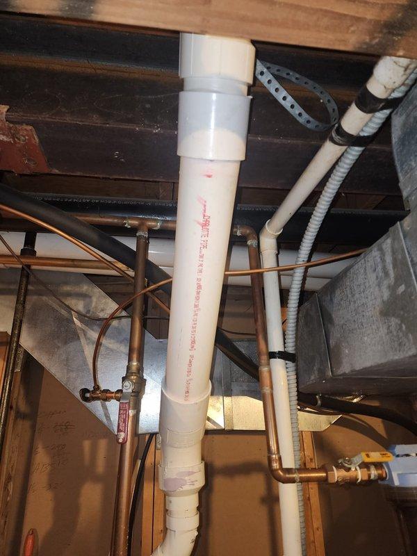 Replaced non-compliant PVC vent piping on water heater installation to meet inspector requirements. Installed proper ASTM-rated solid core PVC pipe and fittings, rebuilding from the horizontal coupling back to the tank with exact fitting setup as specified. Work completed to ensure proper venting system compliance with local code requirements.