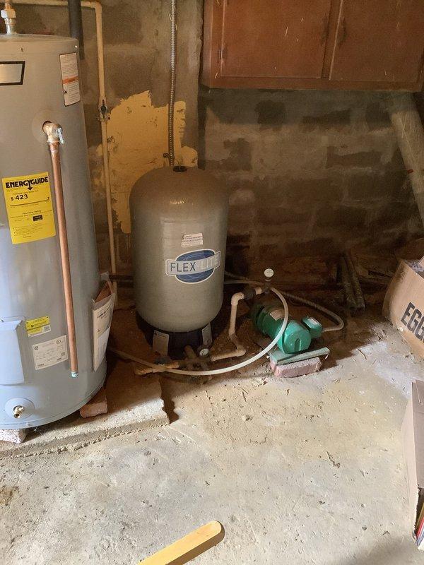 Responded to customer complaint of water pooling and freezing on patio at 150-year-old residence. Inspection revealed leak originating from water system in basement, specifically around connections between water heater and pressure tank. Repaired damaged pipe connections and replaced worn gaskets to restore proper system function, eliminating the source of leakage.