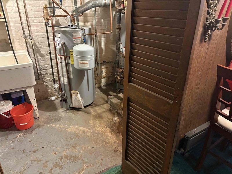 Performed inspection of 1998 steam boiler system exhibiting flame rollout issues at front of unit. Observed significant plugging in heat exchanger. Documented condition with photos of boiler assembly and surrounding mechanical area. System requires replacement due to safety concerns; boiler efficiency rating at 89%.