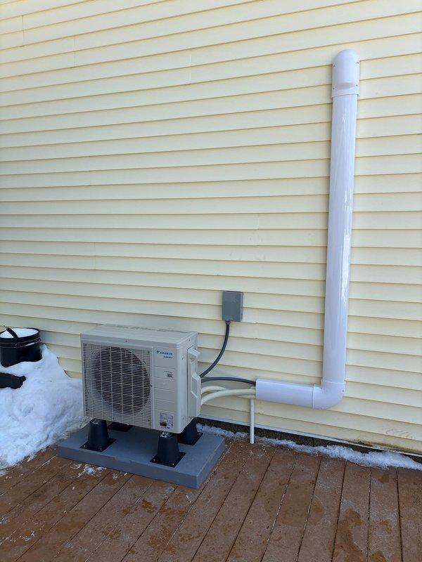 Completed installation of a Daikin mini-split system for garage application, including mounting the outdoor condenser unit on an elevated platform with proper electrical connections. Installed condensate drain line with PVC piping along exterior wall and verified electrical protection with appropriate 15A fuses.
