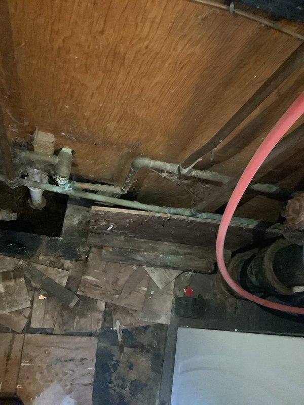 Completed P-trap replacement on tub/shower drain system in 75-year-old residential home. Inspection revealed aged plumbing connections with signs of mineral buildup and corrosion at pipe joints. Accessed underfloor area to complete the replacement, ensuring proper drainage and connection to the main waste line.