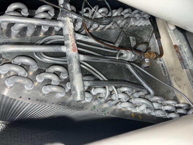 Performed routine furnace maintenance including inspection of evaporator coil assembly. Noted some dust accumulation and minor discoloration at connection points. Heat exchanger fins were examined and found to be in good working condition with no visible damage or significant debris. System is operating properly after service.