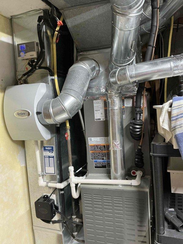 Completed HVAC estimate for replacement of existing system. Current installation features a Trane furnace with associated ductwork, Aprilaire humidifier, PVC drainage pipes, and condensate pump. System appears functional but customer is considering replacement options as discussed during on-site evaluation.