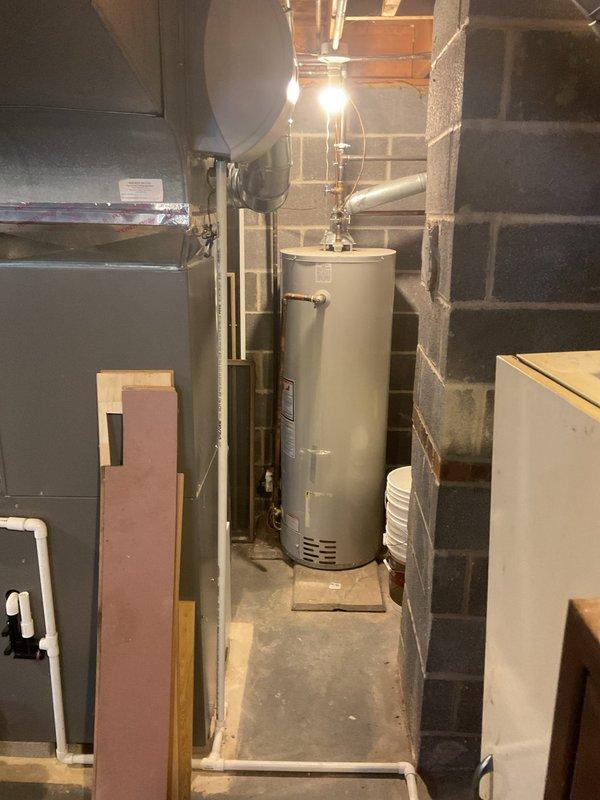 Conducted annual MVP Heating maintenance service in basement utility area. Inspected water heater system, checking pilot lights and gas line connections. Utilized hex tool for minor adjustments to ensure optimal heating system performance.