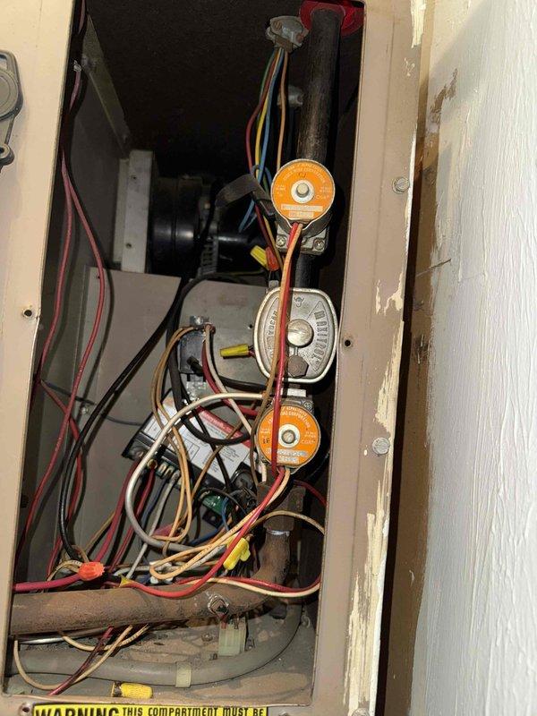 Performed comprehensive furnace tune-up on aging heating system. Inspected electrical connections and wiring in control compartment, noting multiple colored wires with orange wire nuts showing signs of disorganization. Examined heat exchanger components and replaced customer's 14x25x1 air filter to improve system efficiency.