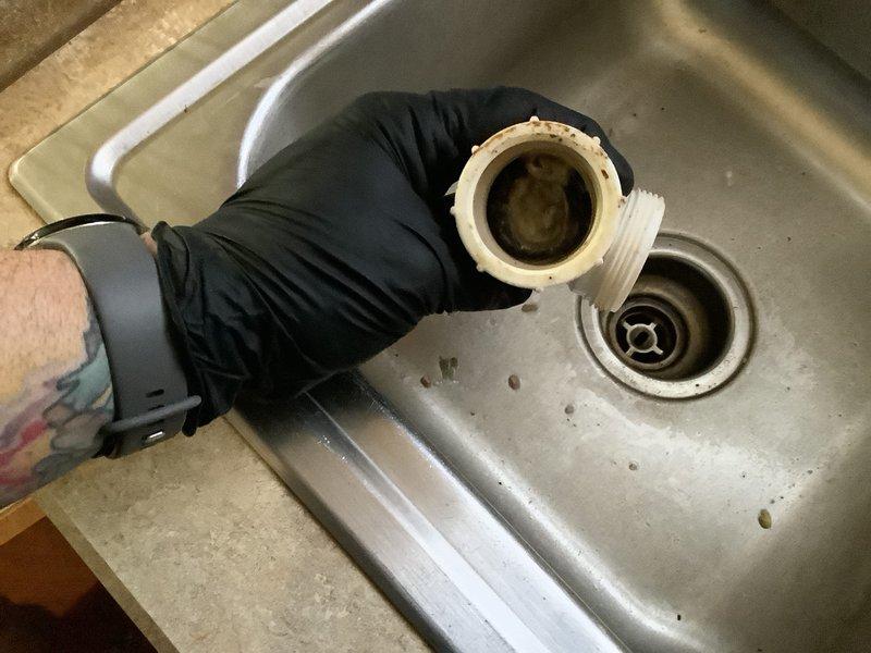 Responded to recurring kitchen sink clogging issue in 50-year-old home. Disassembled P-trap and drain assembly to clear significant buildup of debris. Performed thorough cleaning of drainage components and verified proper flow restoration before reassembly.