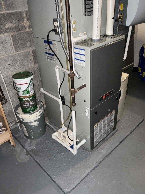 Inspected 12-year-old furnace and found critical crack in primary heat exchanger, requiring full system replacement. Documented existing installation in basement utility room which includes furnace with PVC ventilation pipes, copper line connections, and associated ductwork. Recommended complete HVAC system replacement due to safety concerns with the compromised heat exchanger.