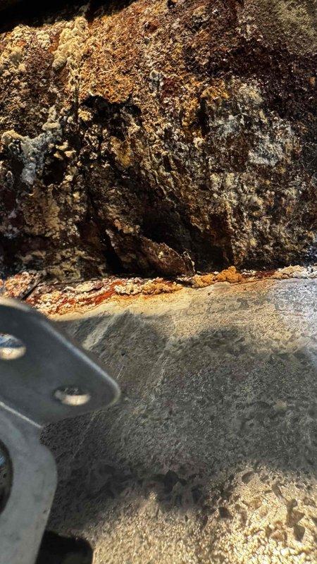 Inspected Weil-McLain LGB6 steam boiler system that customer reported as problematic. Visual examination revealed extensive corrosion and rust damage to the heat exchanger components, with active leaking observed. Documentation of the deterioration was captured for assessment purposes. System requires significant repairs or potential replacement of the heat exchanger assembly due to the advanced state of deterioration.