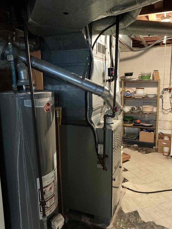 Conducted inspection of 22-year-old furnace with confirmed crack in heat exchanger. Assessment revealed system requires full replacement based on age and safety concerns. Documented condition of existing HVAC system including Rheem water heater and associated ductwork in basement utility area. Customer was left a message to confirm dispatch coordination for replacement.