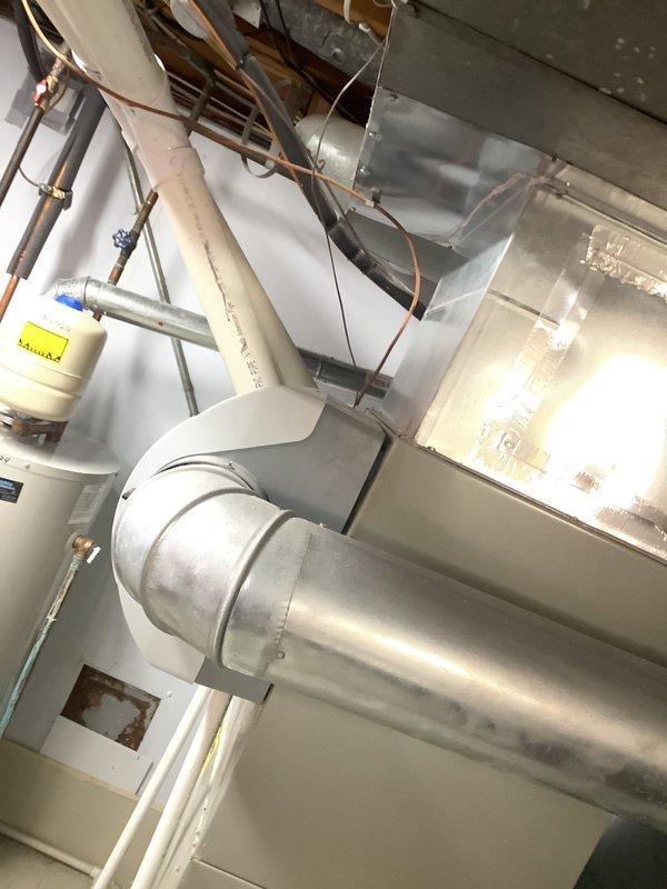 Inspected 14-year-old furnace and identified a cracked heat exchanger, which poses a significant safety hazard. Performed a comprehensive evaluation of the existing HVAC system and provided replacement options with Shea equipment. Documented the current installation configuration in the mechanical room, including ductwork connections and placement relative to other utility equipment.