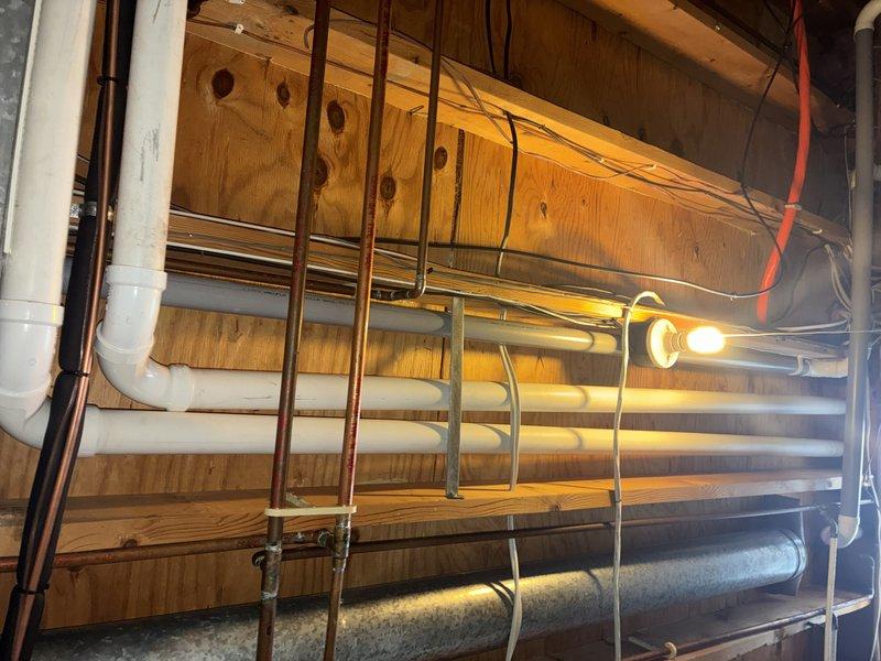 Performed scheduled MVP heating maintenance service. Inspected utility space plumbing infrastructure and heating system components. Examined humidifier assembly, noting filter pad showing normal wear with slight discoloration; all connections and fittings remain secure and functional.