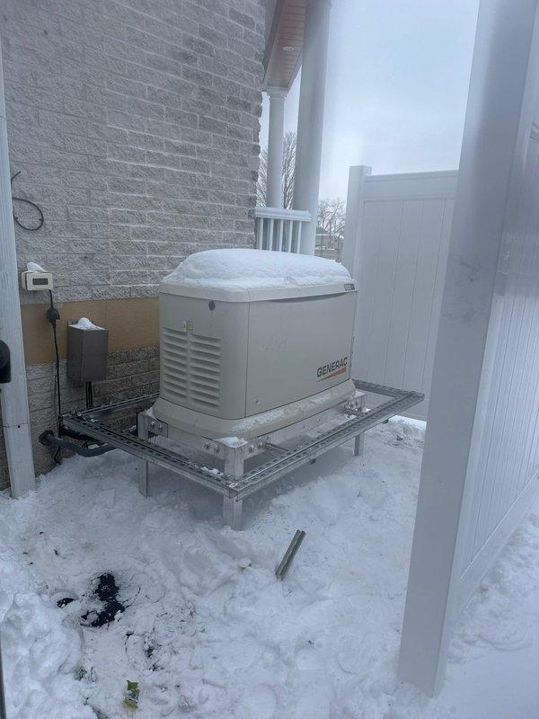 Installed warranty-approved zombie box on customer's Generac backup generator. Completed installation as authorized while customer was not present. Generator is properly mounted on metal platform against exterior brick wall with appropriate electrical connections in place.