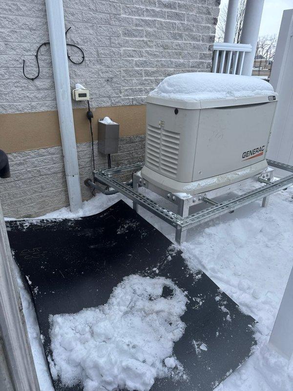Installed warranty-approved zombie box on customer's Generac backup generator. Completed installation as authorized while customer was not present. Generator is properly mounted on metal platform against exterior brick wall with appropriate electrical connections in place.