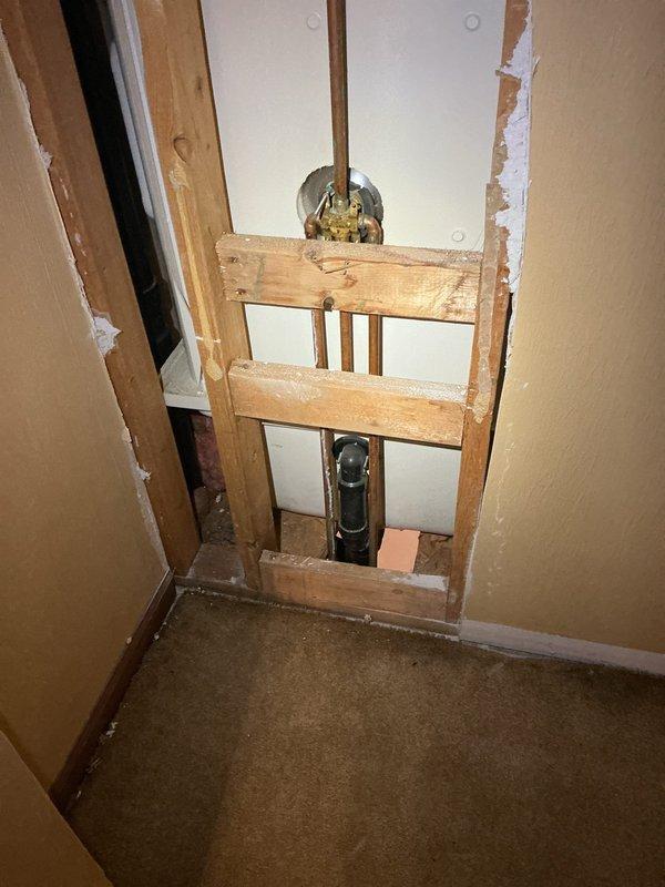 Returned to complete assessment following restoration work. Inspected exposed wall section revealing significant corrosion on copper pipe elbow within the plumbing assembly. Documented condition of brass valve connections and vertical piping through wooden framing structure. Evaluation completed for necessary faucet repairs.