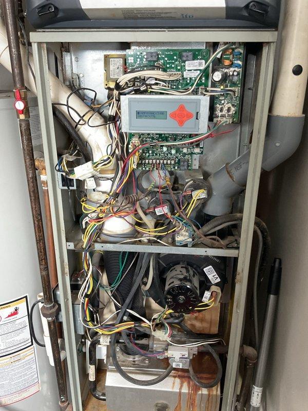 Responded to service call for a 14-year-old furnace displaying error code 1026 on thermostat and 4 red flashing lights on the control board. Upon inspection, found significant corrosion and rust damage on the lower cabinet area, indicating moisture accumulation over time. Diagnosed faulty control module, replaced component, and verified proper system operation with no error codes present.