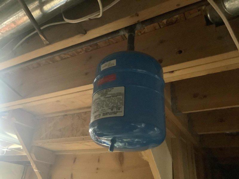 Replaced leaking 40-gallon short water heater, installed new ball valve, and relocated expansion tank by coupling line together in ceiling. Repositioned expansion tank between water heater and ball valve to improve system function. Installed short riser before flue 90s to address observed backdraft issues around the flue.