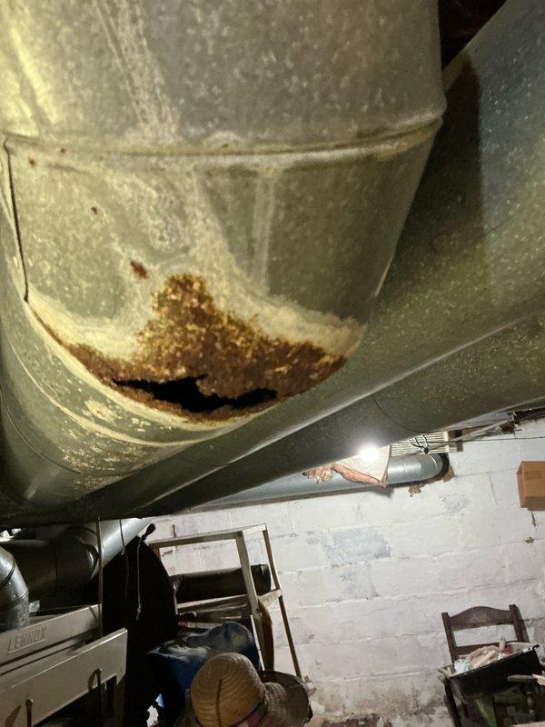 Conducted estimate for furnace replacement for military veteran customer. Inspection revealed electrical panel with proper circuit labeling for HVAC components and discovered significant corrosion damage on ductwork with visible hole formation that will require repair or replacement during system installation.