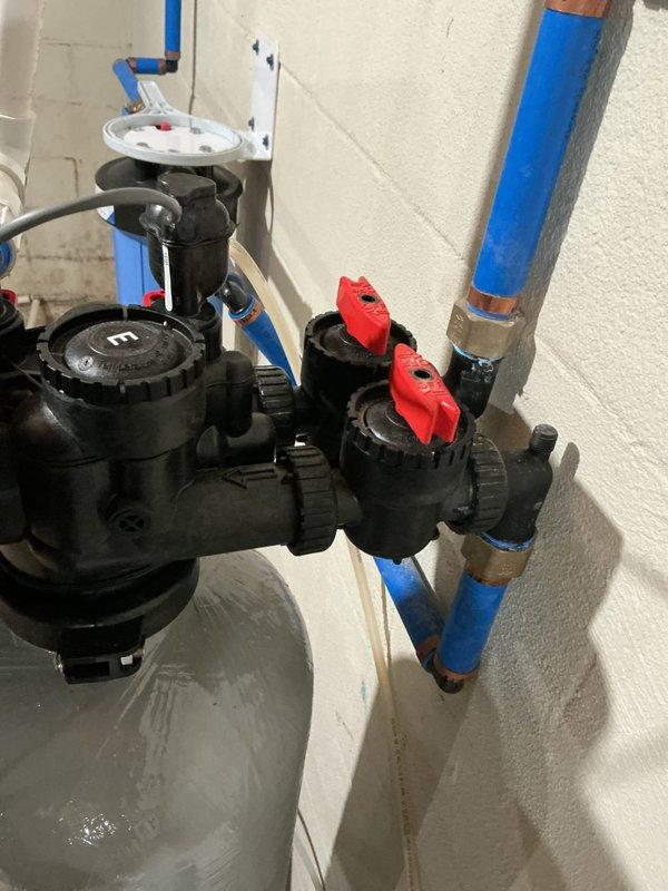 Diagnosed and repaired water softener system that was backing up into salt container. Cleared blockage in brine line that was preventing proper drainage and causing salt to become wet. System is now functioning properly with normal brine draw and proper regeneration cycling.
