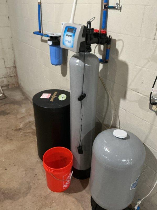 Diagnosed and repaired water softener system that was backing up into salt container. Cleared blockage in brine line that was preventing proper drainage and causing salt to become wet. System is now functioning properly with normal brine draw and proper regeneration cycling.