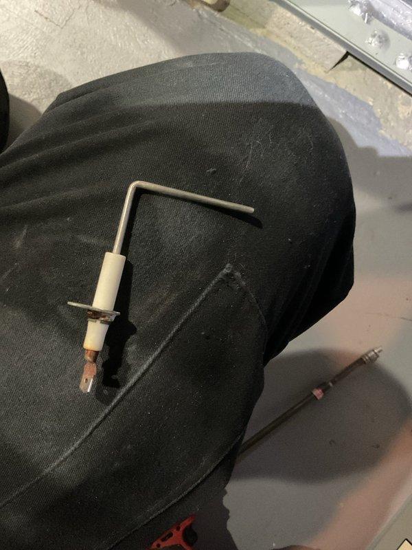 Performed comprehensive furnace tune-up service including inspection and cleaning of ignition electrode assembly. Removed and examined spark igniter, noting minor wear and discoloration at the tip indicating normal operational use. Reinstalled component after verification of proper functionality to ensure reliable heating system operation.