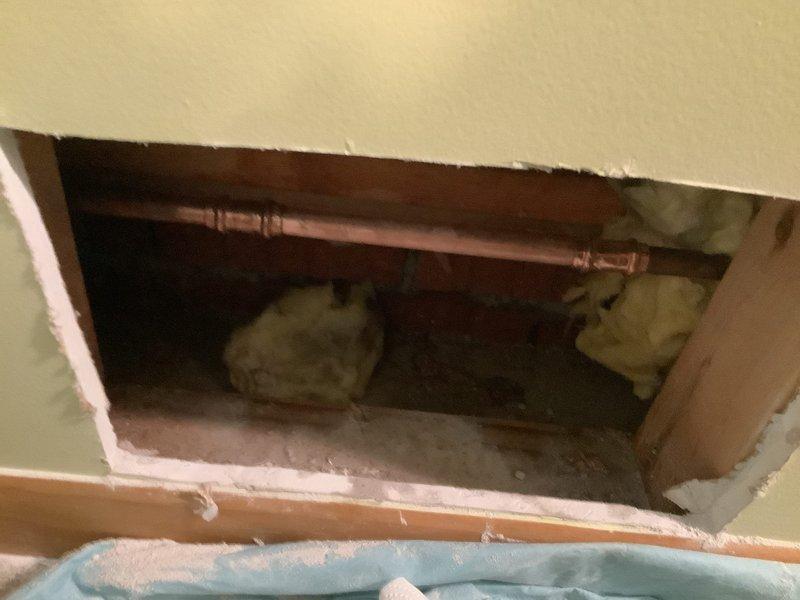 Accessed wall cavity to diagnose and repair a burst copper water line. Located frost-covered pipe within structural framing, opened drywall for proper access, and completed necessary repairs. Parts were ordered and received for the repair work as specified.