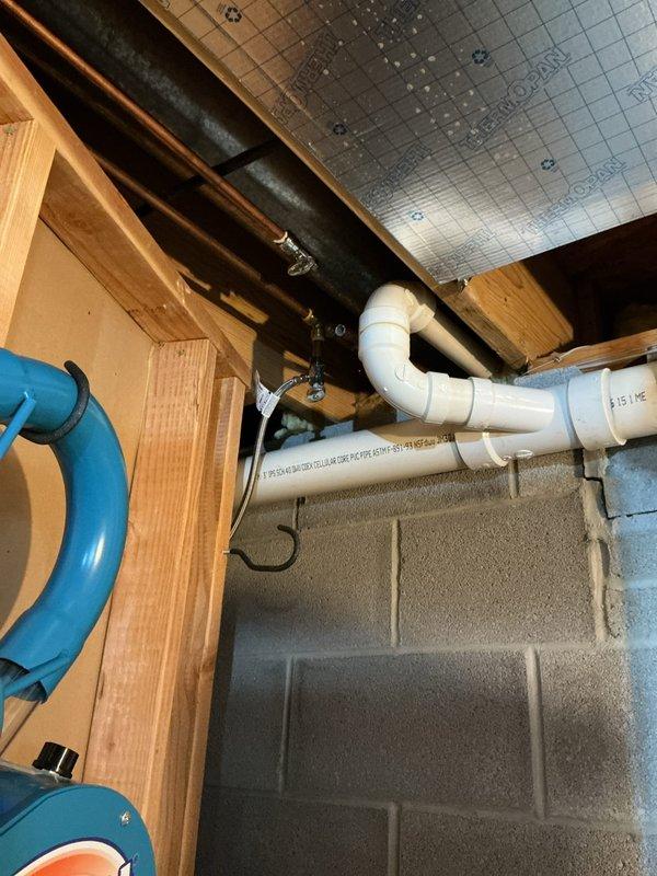 Responded to emergency call for broken pipe in garage with customer unable to locate shutoff valve. Located and repaired damaged PVC drainage pipe in basement/utility area, which showed signs of leakage evidenced by water staining on concrete floor. Installed new PVC fittings and ensured proper connection of P-trap to vertical drain pipe, restoring full functionality to the plumbing system.