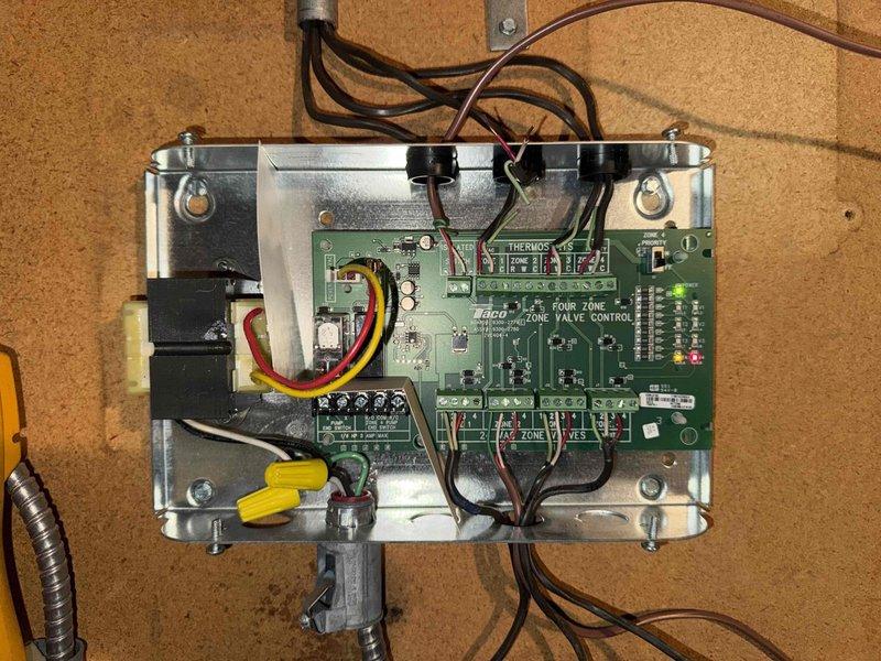 Diagnosed and repaired 3-year-old heating system with zone control valve issue. Inspection of the Four Zone Valve Control board revealed non-functioning indicator light for affected zone. Replaced faulty zone control module and verified proper operation of all zones with successful system testing.