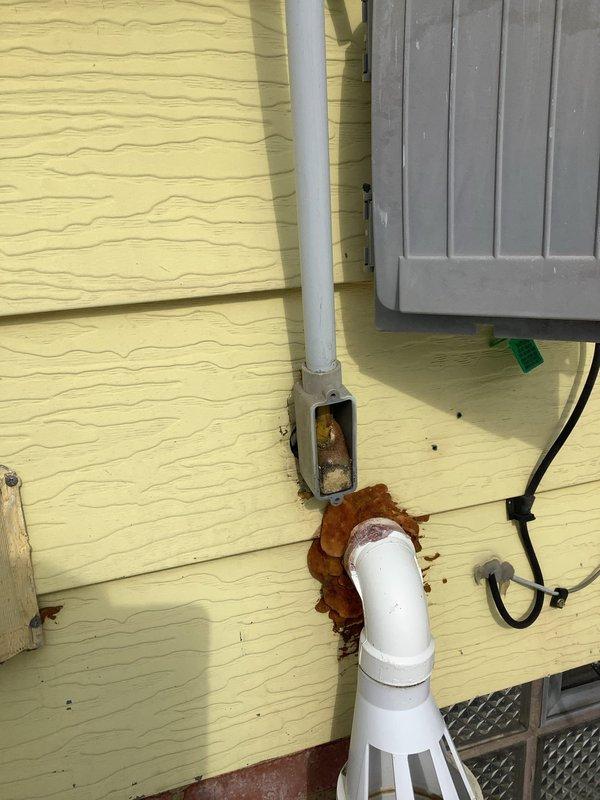 Responded to a no-power call at an 83-year-old residence with a broken outdoor electrical line. Inspection revealed significant corrosion at the service entrance, with visible rust damage where the conduit connects to the exterior wall. Replaced damaged service entrance cable and weatherhead, restored power to the main panel in basement, and verified all circuits functioning properly.