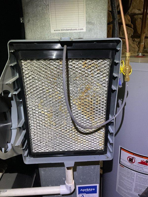 Performed scheduled MVP Heating maintenance visit at customer's request. Inspected and serviced AprilAire humidifier component, noting discoloration on the mesh filter element indicating usage wear. Utilized hex key tool for necessary adjustments to system components during the maintenance procedure.