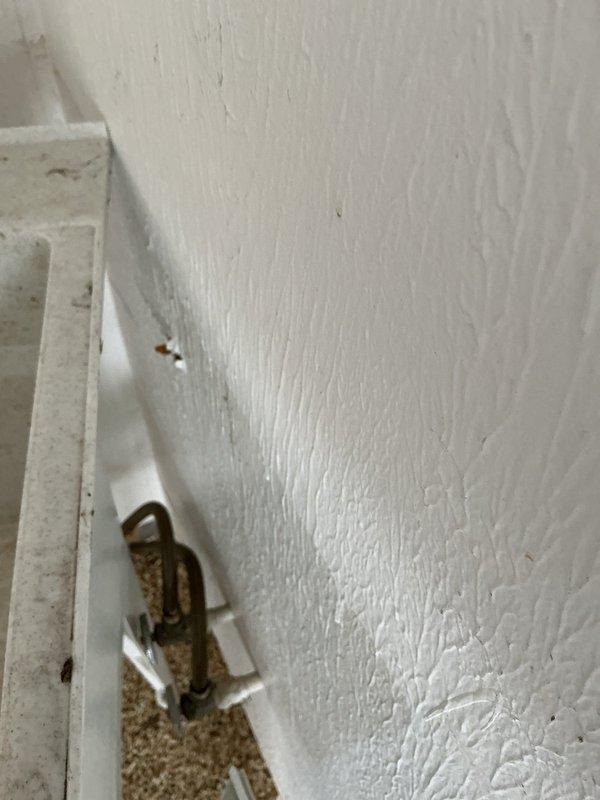 Located and repaired a burst pipe in garage wall that was leaking water near utility sink and through an electrical outlet. Shut off water supply, removed damaged section of wall to access the compromised copper pipe, replaced the affected pipe segment, and verified proper water flow with no leaks after repair.