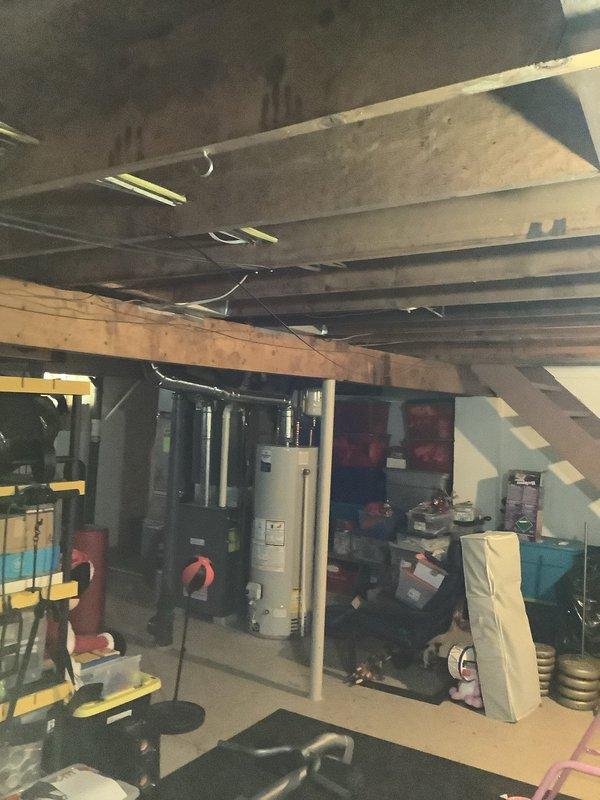 Conducted service call to evaluate basement area for installation of new lighting fixtures and outlets. Inspected existing electrical infrastructure in unfinished basement with exposed joists and beams. Assessed optimal placement locations for new outlets and fixtures around water heater and storage areas to improve functionality and safety in the dimly lit space.