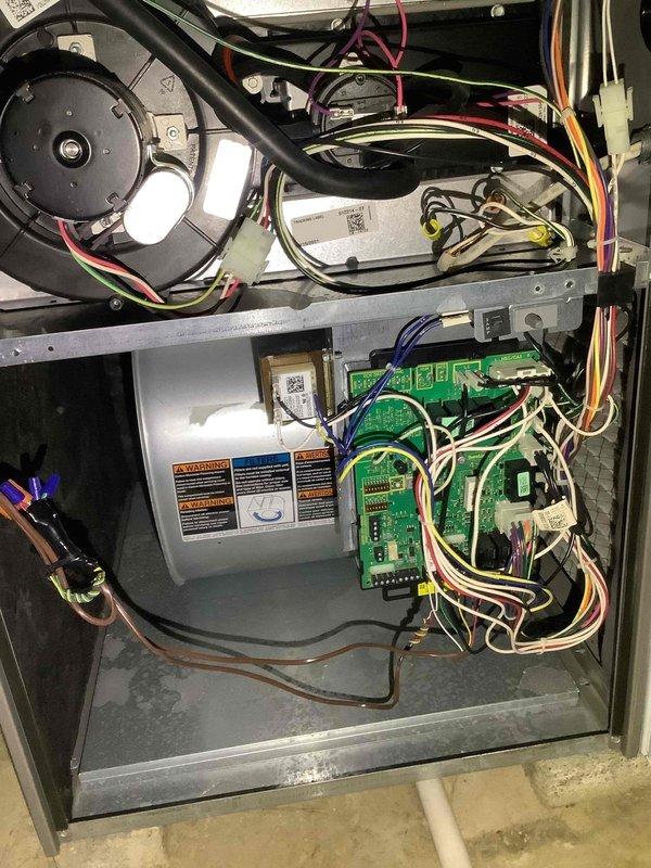 Performed routine maintenance on 4-year-old heating system. Inspected control board circuitry including DIP switches, LED display, and terminal connections. Examined blower motor assembly and verified proper electrical connections between control board and system components.