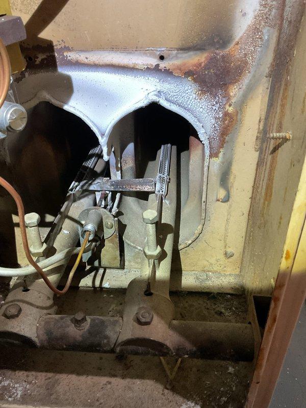 Diagnosed non-functioning heating system with significant corrosion and rust on heat exchanger. Inspection revealed deterioration of metal components and potential safety hazards. Recommended system replacement due to age-related wear and compromised operational integrity.