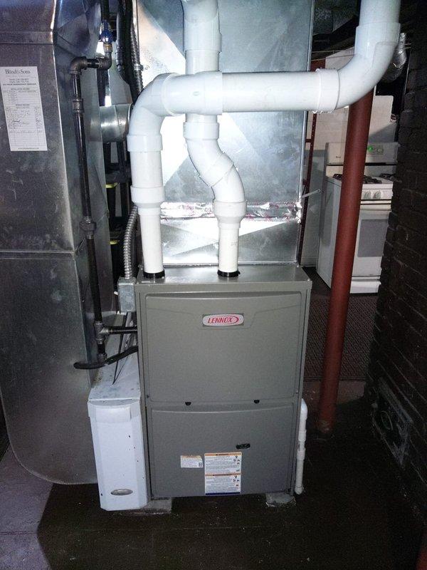 Installed a new Lennox 90% efficient furnace in customer's utility room. System includes properly connected PVC ventilation pipes and integrated ductwork. Verified proper operation with temperature readings showing 59.0°F at completion of installation.