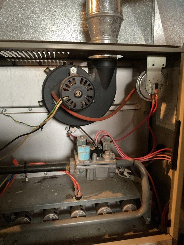 Diagnosed 25-year-old furnace with temperature regulation issues causing inconsistent heating cycles where temperature would drop into 60s before reactivation despite 70°F setpoint. Performed visual inspection of blower motor assembly and gas valve components, documenting condition with photos for assessment of system functionality.