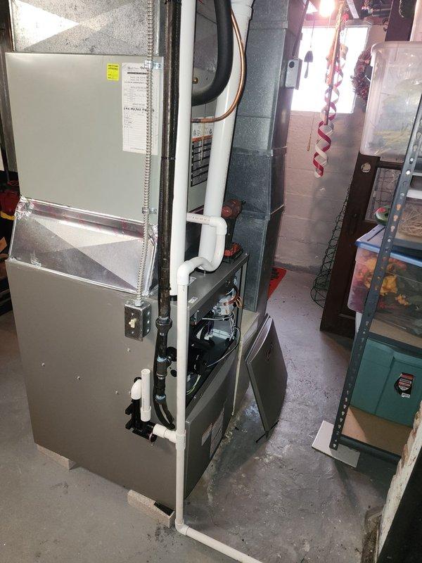 Successfully installed a new 93% efficient furnace in the basement utility room. The installation included proper connection of white PVC venting pipes and copper lines, with all components securely mounted against the concrete block wall. Visual inspection confirms clean installation with appropriate clearances and proper integration with existing mechanical systems.
