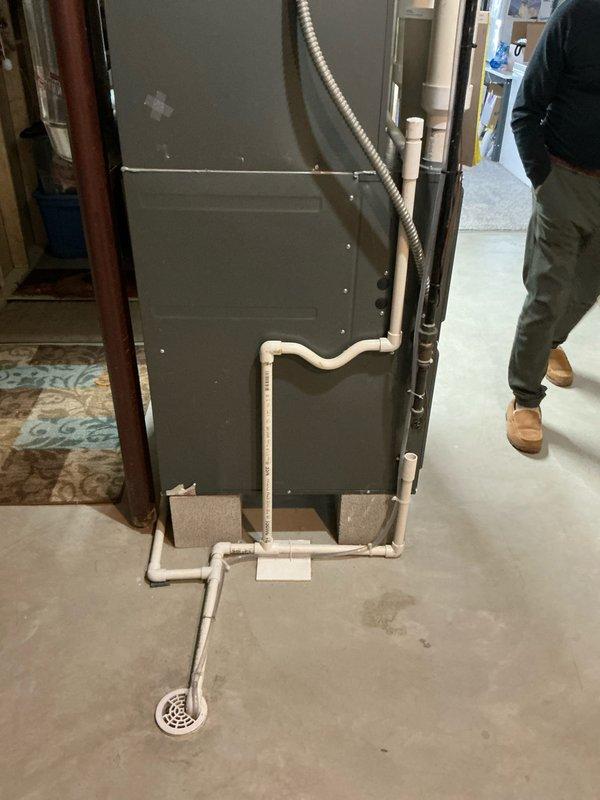 Conducted evaluation of 6-year-old Goodman furnace system that has previously undergone ignitor and blower motor replacements. System features PVC condensate drainage configuration running to floor drain and connects to galvanized trunk line with multiple PVC pipe connections. Provided replacement estimate for unit #1291 with documentation through comprehensive photos of the existing installation and ductwork configuration.
