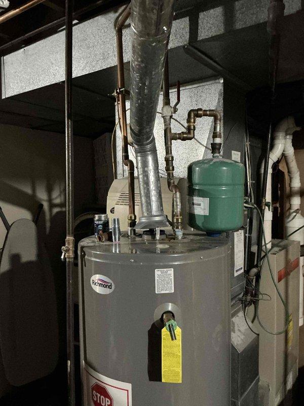 Performed comprehensive assessment of 34-year-old failed furnace with non-functional blower motor. Completed full system evaluation and provided replacement estimate for furnace, air conditioner, and water heater. Documented existing Richmond water heater installation with connected exhaust venting and expansion tank for reference in replacement proposal.